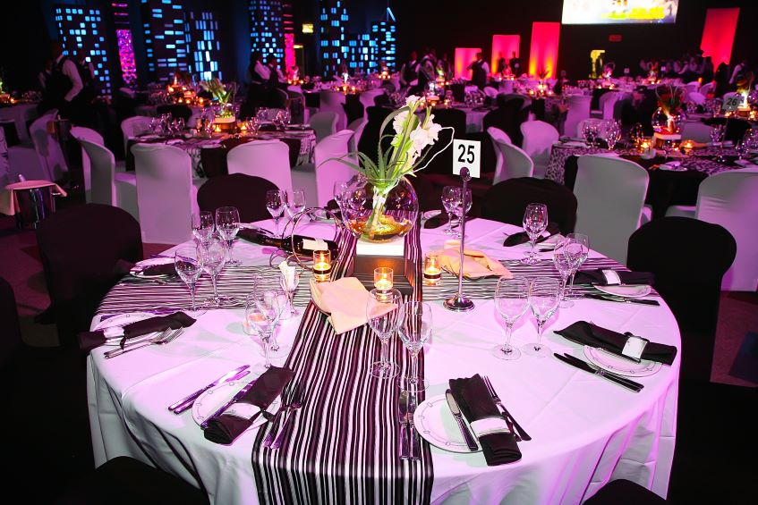 Annual Charity Gala - Elegant venue with round tables and purple lighting