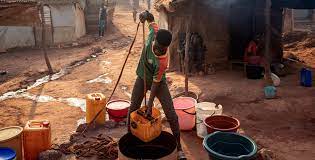 Woman collecting water with traditional containers - showing the daily challenge of water access