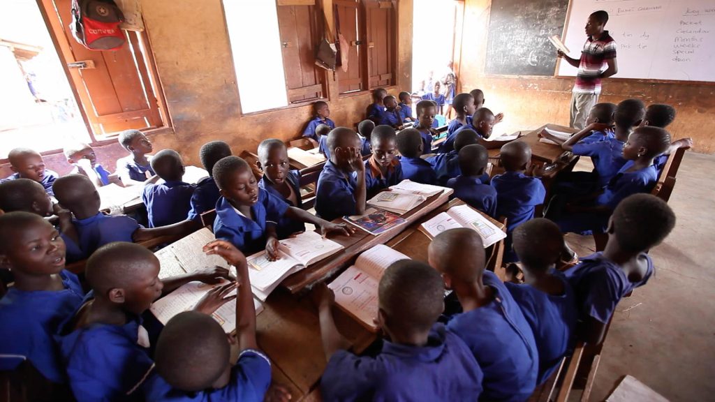 Students in blue uniforms learning in a classroom in Ghana