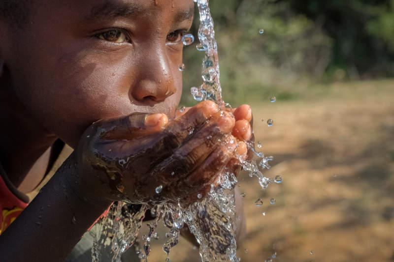 Child drinking clean water - representing the impact of clean water access